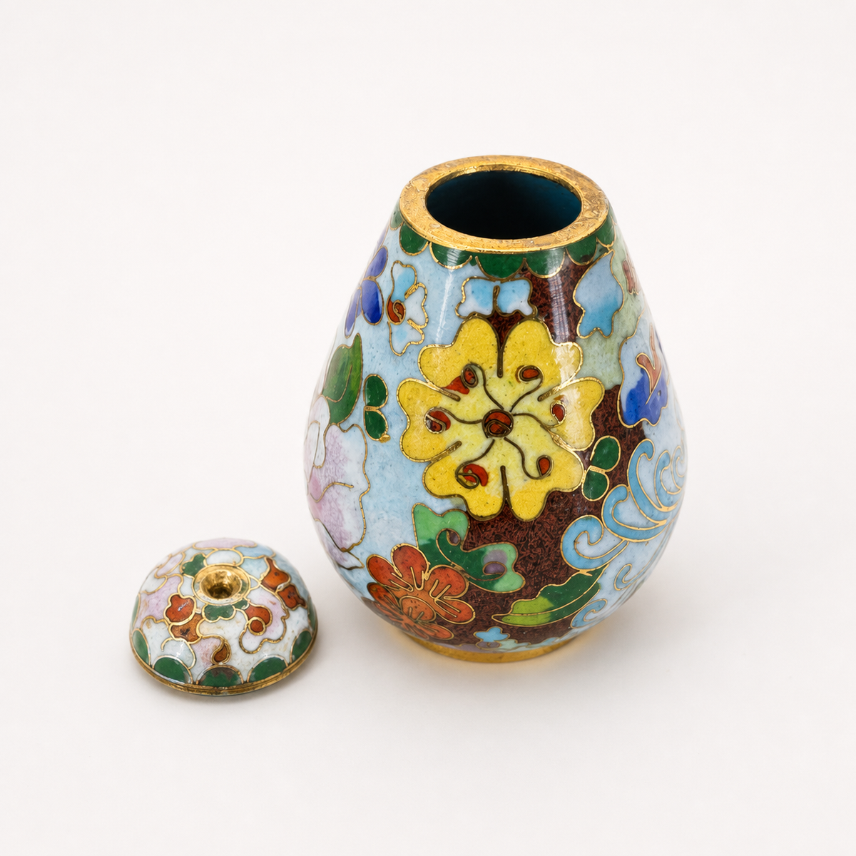 Open inspection view of miniature floral cloisonné covered vase and cap